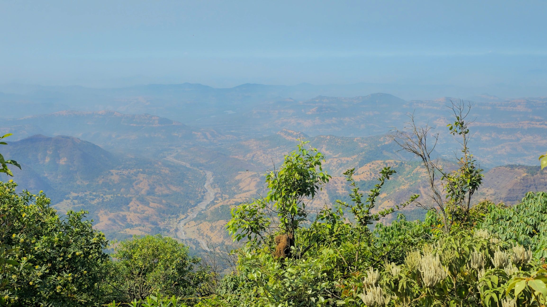 Mountain landscape with layered hills valleys and distant horizon under clear sky